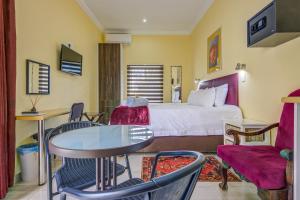 a hotel room with a bed and a table and chairs at Edenvale Guest House in Edenvale