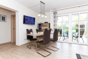 Un comedor con mesa y sillas de madera. en Cliner Nordseehus, en Carolinensiel