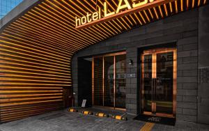 a hotel entrance with a neon sign on a building at Hotel Lassa in Seoul