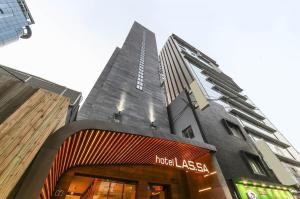 ソウルにあるHotel Lassaのホテルの前にラゼラの看板が立つ高層ビル