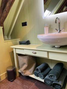 a bathroom with a sink and towels under a mirror at B&B Hoogstraat in Dokkum