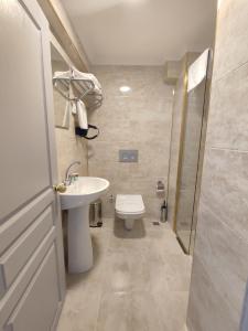 a bathroom with a toilet and a sink and a shower at GRAND KENT OTEL in Bilecik