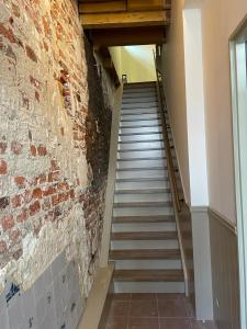 een trap in een gebouw met een bakstenen muur bij B&B Hoogstraat in Dokkum