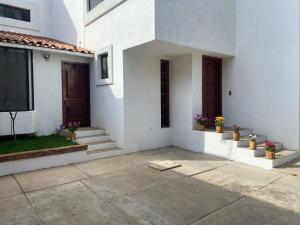 een wit huis met trappen en deuren en potplanten bij Casa Violetas in Oaxaca City