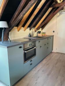 a kitchen with a sink and a stove at B&B Hoogstraat in Dokkum