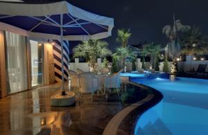 a swimming pool with a table and an umbrella at Exquisite Villa with Private Pool in Antalya in Belek