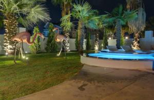 a pool with two flamingos in a yard at night at Exquisite Villa with Private Pool in Antalya in Belek