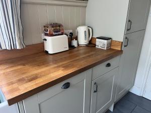 a kitchen counter with a coffee maker on top of it at Cosy cottage in town centre in Havant