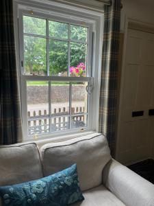 a couch sitting in front of a window at Cosy cottage in town centre in Havant