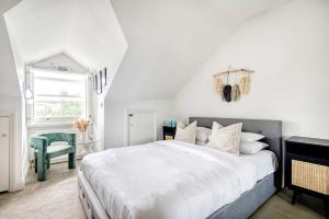 - une chambre blanche avec un grand lit et une chaise dans l'établissement The Luxury 'Treehouse' - One bed Little Venice, à Londres