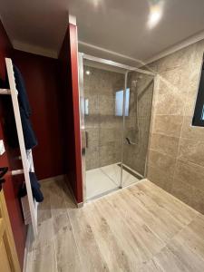 La salle de bains est pourvue d'une douche avec une porte en verre. dans l'établissement Chalet moderne au bord d'un lac, à Saint-Sauveur-lès-Bray