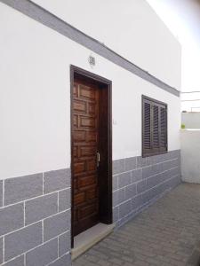 ein Gebäude mit einer Holztür und einem Fenster in der Unterkunft HERVEME AGAETE in Agaete