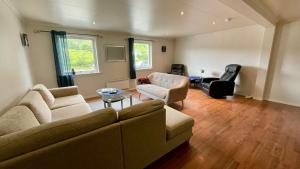 ein Wohnzimmer mit einem Sofa und 2 Stühlen in der Unterkunft EG Apartment in Leknes