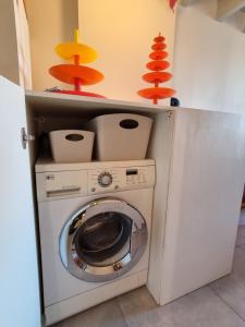 - un lave-linge et un sèche-linge dans une petite pièce avec des tons orange et jaunes dans l'établissement LOC'MARIA, à Sauzon