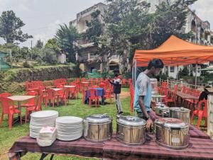 a man standing in front of a table with drums at Vpr residency ooty in Ooty