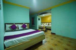 a bedroom with a large bed with purple pillows at Vpr residency ooty in Ooty