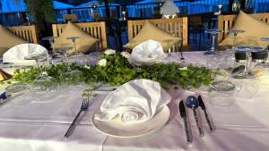 a table with white plates and napkins on it at Vannee Golden Sands Beachfront Resort in Haad Rin
