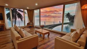 a living room with couches and a view of the ocean at Vannee Golden Sands Beachfront Resort in Haad Rin