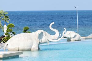 two elephant statues in the water at a resort at Vannee Golden Sands Beachfront Resort in Haad Rin