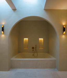uma grande banheira num quarto com duas luzes em Cortijo Boutique Siete Calas em Rodalquilar