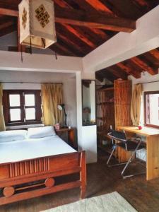 帕坦的住宿－PatanGhar Homestay，一间卧室配有一张床、一张书桌和一张书桌