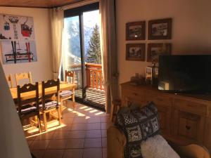 ein Wohnzimmer mit einem TV und einem Esstisch in der Unterkunft Chalet Individuel Orcières Merlette 1850m Pied des Pistes Vue Magnifique sur les Montagnes in Orcières