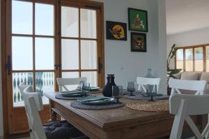uma sala de jantar com uma mesa de madeira e cadeiras brancas em Finca Es Verger em Esporles