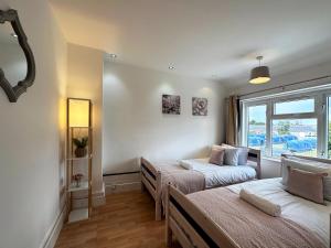 - une chambre avec 2 lits et une fenêtre dans l'établissement Maria's House in East London, à Dagenham