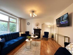 un soggiorno con divano blu e camino di Maria's House in East London a Dagenham