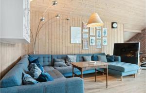 Bøtø ByにあるAwesome Home In Idestrup With 3 Bedrooms, Sauna And Wifiのリビングルーム(青いソファ、テーブル付)