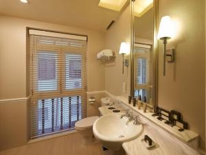 a bathroom with a sink and a toilet and a mirror at Aurum Royal in Singapore