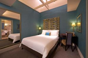 a bedroom with a bed and a desk with a mirror at Aurum Royal in Singapore +17 photos
