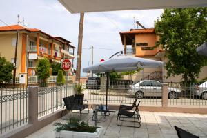 a patio with chairs and an umbrella and a stop sign at POSIDONIA RESORT No4 in Nea Vrasna