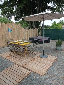a table and chairs and an umbrella on a patio at Logement moderne in Surgères