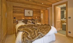 - une chambre avec un lit et une fausse couverture en fourrure dans l'établissement Chalet Cree - Haute Collection, à Chamonix-Mont-Blanc