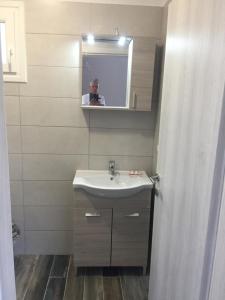 a man taking a picture of a bathroom with a sink at NA House 2 in Nea Kalikratia