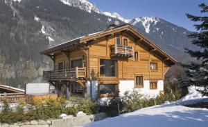 une cabane en rondins dans les montagnes avec de la neige au sol dans l'établissement Chalet Cree - Haute Collection, à Chamonix-Mont-Blanc