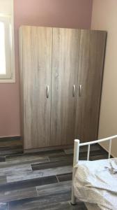 a bedroom with a wooden cabinet next to a bed at NA House 2 in Nea Kalikratia