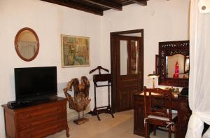 a living room filled with furniture and a television at Katsaneiko Mansion in Afitos