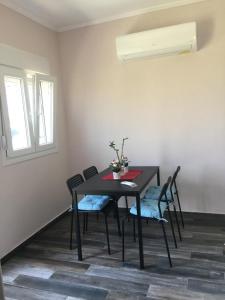 a dining room table with chairs and a window at NA House 2 in Nea Kalikratia