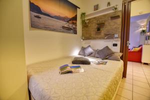 Un dormitorio con una cama con dos libros. en Studio Apartment Casa Enjoy Lago di Como, en Acquaseria