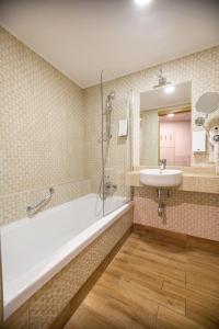 a bathroom with a tub and a sink at Wellton Riga Hotel & SPA in Rīga