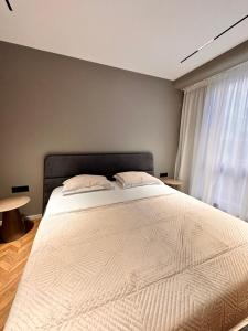 a bedroom with a large bed and a window at AGATE HOTEL self check in in Tirana
