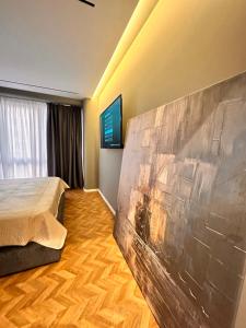 a bedroom with a bed and a painting on the wall at AGATE HOTEL self check in in Tirana