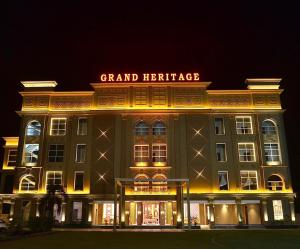 a grand heritage building with a sign on it at night at Grand Heritage Hotel & Resort in Ludhiana