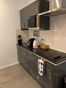 uma cozinha com um balcão preto e um lavatório em Beachfront self contained studio em White Beach