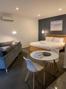 um quarto com uma cama, uma mesa e um sofá em Beachfront self contained studio em White Beach