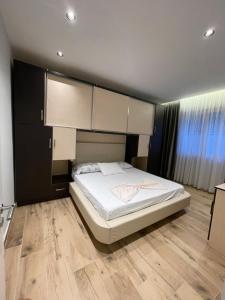 Un dormitorio con una cama grande con sábanas blancas. en Leonard's Apartment, en Durrës