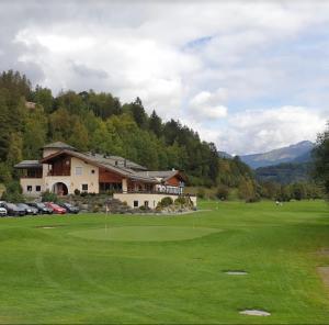 einen Golfplatz mit Clubhaus und Grün in der Unterkunft Bed and Breakfast Darlux in Bergün