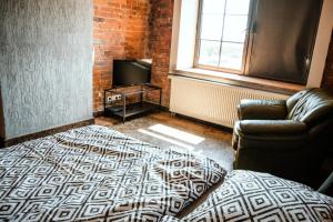 a living room with a couch and a television at RedCity Loft 25 in Żyrardów